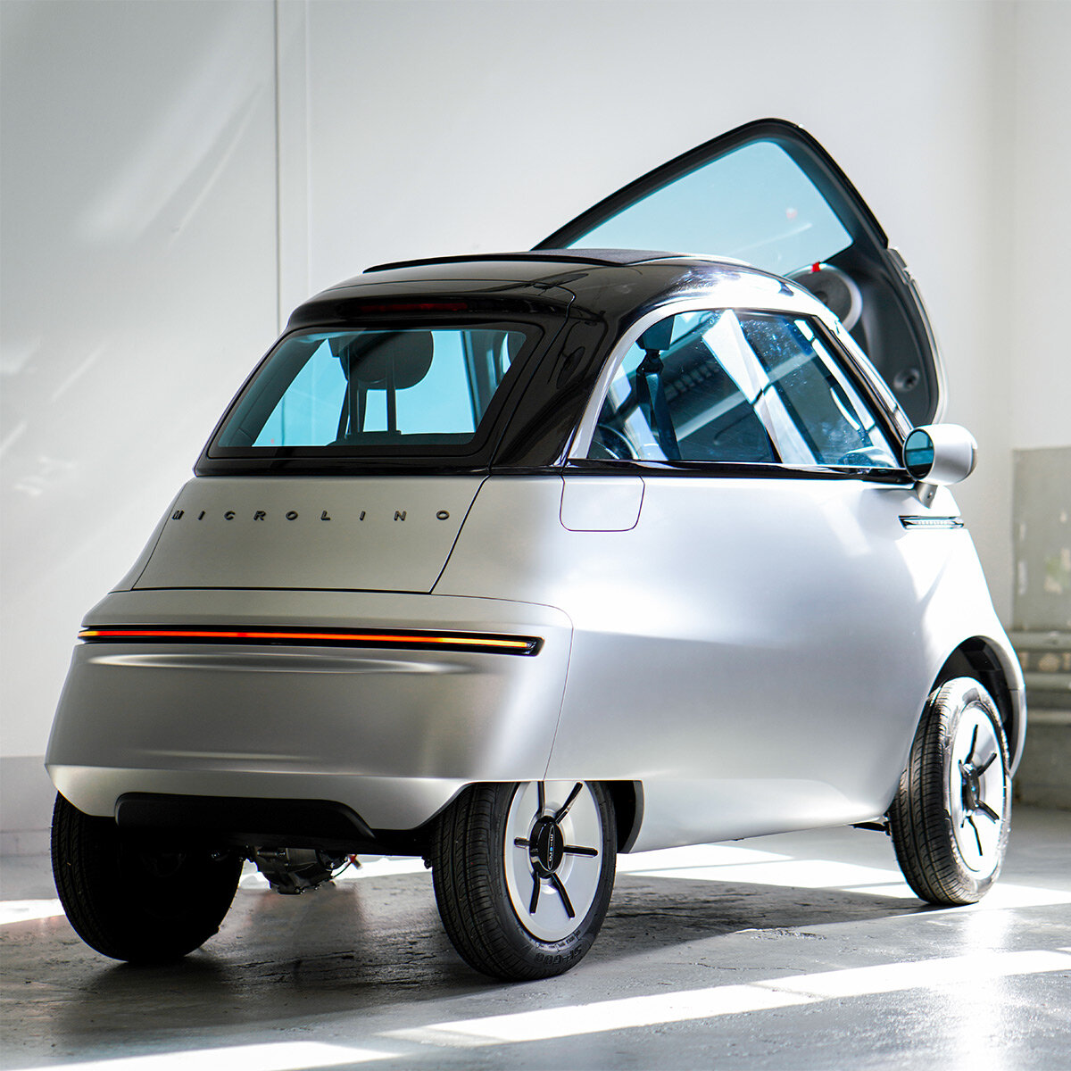 Microlino med åpen frontdør i showroom